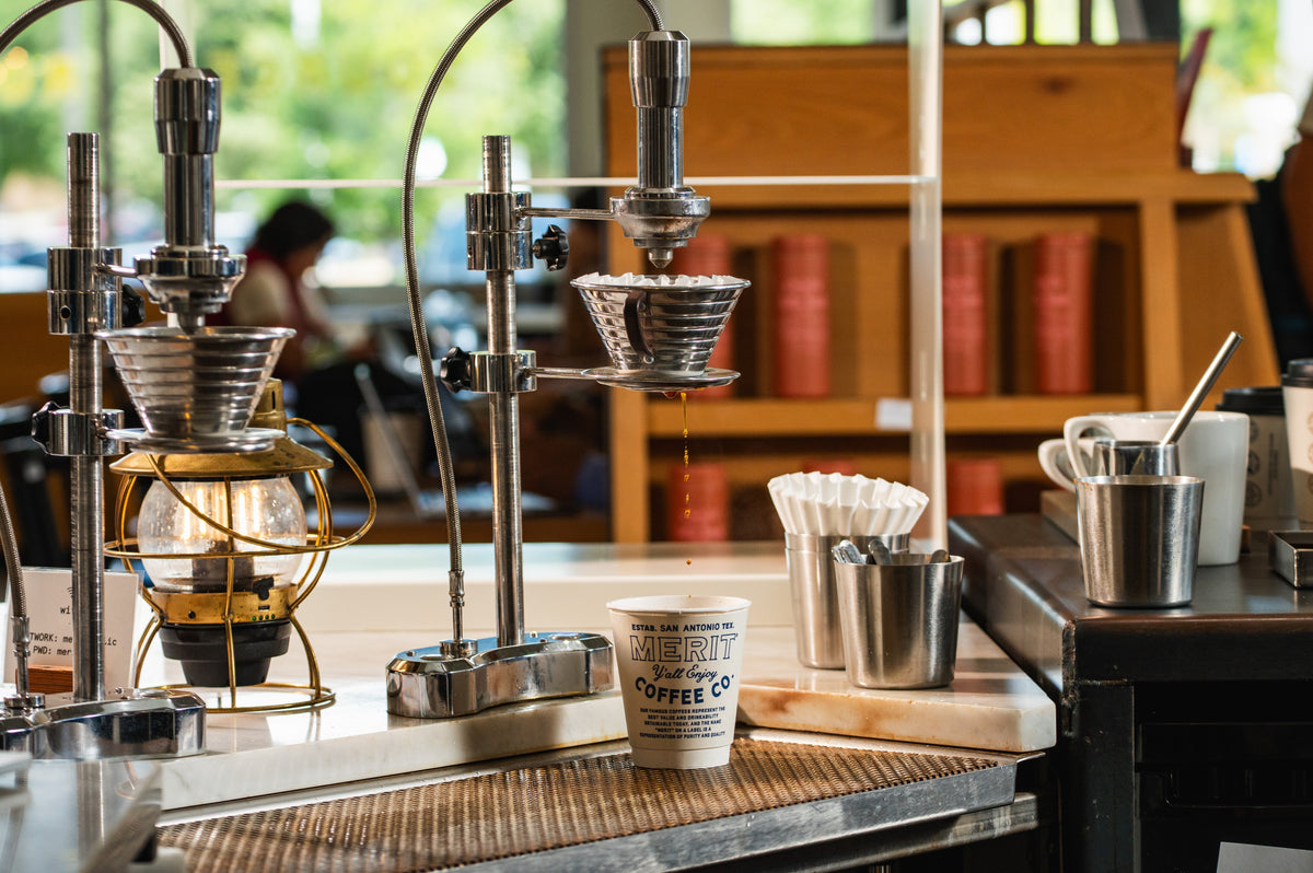 Pour-over brew bar at a Merit Coffee café with drippers, filters, and a coffee cup, showing the best way to make coffee